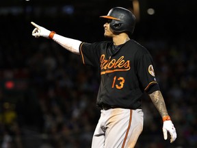 Baltimore Orioles' Manny Machado points to a teammate who scored on a two-run single during the fourth inning of the team's baseball game against the Boston Red Sox at Fenway Park in Boston Friday, May 18, 2018.