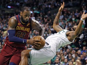 Cleveland Cavaliers forward LeBron James (23) drives against the defense of Boston Celtics forward Marcus Morris during the first quarter of Game 1 of the NBA basketball Eastern Conference Finals, Sunday, May 13, 2018, in Boston.