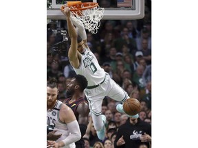 Boston Celtics forward Jayson Tatum (0) dunks over Cleveland Cavaliers forward Jeff Green during the first half in Game 7 of the NBA basketball Eastern Conference finals Sunday, May 27, 2018, in Boston.