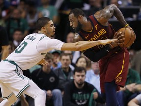 Cleveland Cavaliers forward LeBron James, right, looks to make a move against Boston Celtics forward Jayson Tatum (0) during the second half of Game 1 of the NBA basketball Eastern Conference Finals, Sunday, May 13, 2018, in Boston.
