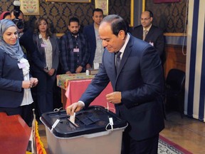 FILE - In this March 26, 2018 file photo, provided by Egypt's state news agency, MENA, Egyptian President Abdel-Fattah el-Sissi votes in Cairo, Egypt. On Sunday. May 13, 2018, a top newspaper editor known to be close to el-Sissi subtly suggested that the Egyptian leader be allowed to rule beyond the maximum two, four-year terms set by the constitution. Yasser Rizq did not explicitly call for amending the constitutional clause limiting the number of terms a president can serve, but argued that time was running out for the emergence of a viable replacement. (MENA via AP, File)