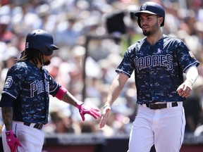 San Diego Padres' Eric Hosmer, right, celebrates with Freddy Galvis after scoring a run on an RBI-single by Travis Jankowski during the third inning of a baseball game against the St. Louis Cardinals in San Diego, Sunday, May 13, 2018.