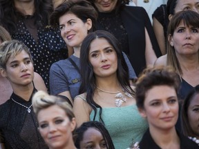 Sofia Boutella, from centre left, Salma Hayek and Patty Jenkins stand as part of 82 film industry professionals on the steps of the Palais des Festivals to represent, what they describe as pervasive gender inequality in the film industry, at the 71st international film festival, Cannes, southern France, Saturday, May 12, 2018. Since the Cannes Festival was created, 82 films directed by women have been included in official competition, whilst 1,645 films directed by men were selected.