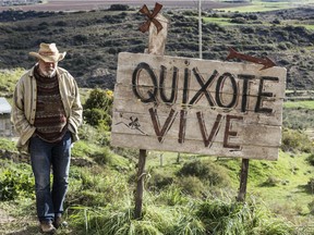 Terry Gilliam stands next to a sign that reads "Quixote lives."