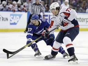 Tampa Bay Lightning centre Yanni Gourde, left, knocks the puck away from Washington Capitals right wing T.J. Oshie during the first period of Game 2 of the Eastern Conference final on Sunday, May 13, 2018.