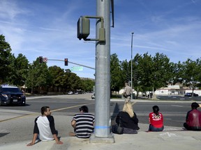 Students wait on a curb outside Highland High School in Palmdale, Calif. as Sheriff search the school on Friday, May 11, 2018. A high school student was shot in the arm Friday at high school in the California city of Palmdale and a 14-year-old suspect was taken into custody, officials said.
