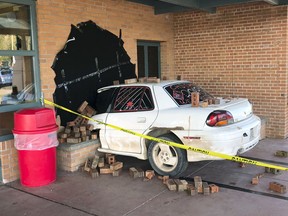 This photo taken Wednesday, May 16, 2018, and provided by Ritchie Narges, shows what looks to be a car that crashed into the principal's office at Cumberland High School in Cumberland, Wis., but is actually an illusion created for a senior class prank. Students at the school used a junk car, some bricks, some tape and a black tarp to make it look like the car had crashed into their school. Police arrived on the scene only to realize it wasn't really a wreck. The police department wrote on Facebook that it was "one of the best senior pranks."