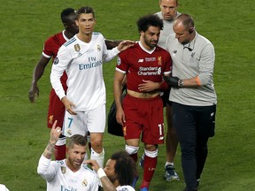 Real Madrid's Cristiano Ronaldo, left, walks next to Liverpool's Mohamed Salah, 2nd right, as Salah leaves the pitch during the Champions League Final soccer match between Real Madrid and Liverpool at the Olimpiyskiy Stadium in Kiev, Ukraine, Saturday, May 26, 2018.