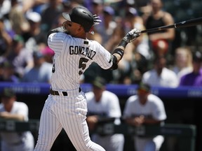 Colorado Rockies' Carlos Gonzalez follows the flight of his two-run home run off Cincinnati Reds starting pitcher Matt Harvey in the first inning of a baseball game Sunday, May 27, 2018, in Denver.
