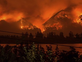 FILE - This Sept. 4, 2017, file photo provided by KATU-TV shows a wildfire as seen from near Stevenson, Wash., across the Columbia River, burning in the Columbia River Gorge above Cascade Locks, Ore. A teenager who started the major wildfire in the scenic Columbia River Gorge in Oregon has been ordered to pay restitution for at least the next decade, though it's unlikely the boy will ever cover his nearly $37 million bill.