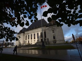 A pedestrian walks past the Supreme Court of Canada in Ottawa, Oct. 18, 2013. The Supreme Court of Canada says a Jehovah's Witness who was expelled from his Calgary congregation cannot take his case to a judge.