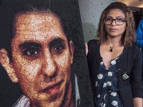 Ensaf Haidar stands next to a poster of a book of articles written by the imprisoned Saudi blogger and Haidar's husband, Raif Badawi, on June 16, 2015 in Montreal. Montreal city council is expected to debate a resolution today to have jailed Saudi blogger Raif Badawi named an honorary Montreal citizen.