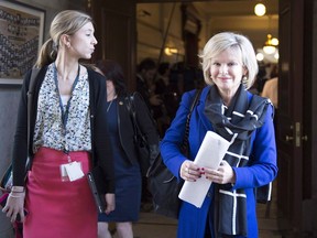 Quebec Tourism Minister Jullie Boulet, right, walks to question period with press attache Marie-Emmanuelle Cadieux at the legislature in Quebec City on April 14, 2016. A fifth member of Quebec Premier Philippe Couillard's Liberal cabinet has announced she won't seek re-election later this year. Tourism Minister Julie Boulet says she no longer has the energy or the motivation to run again.