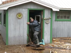 Darlene McNee films her husband Robert as he attempts to survey damage at their cottage in Chipman, N.B., in this recent handout photo taken from video.