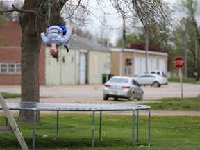 A child does a back flip on a trampoline in Nickerson, Nebraska on Tuesday, April 19, 2016. After a lengthy research process, Quebec's language watchdog has concluded the word 'trampoline,' which in French is most often considered a masculine noun, can also be used with the feminine definite article 'la.'