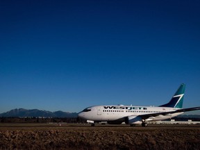 A Westjet Boeing 737-700 taxis to a gate after arriving at Vancouver International Airport in Richmond, B.C., on Monday February 3, 2014. WestJet Airlines says it's experiencing a computer system outage that is expected to cause delays in its operations.