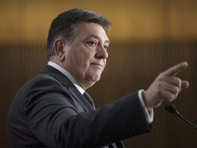 Provincial Finance Minister Charles Sousa takes questions from journalists during a pre-budget lock-up as the Ontario Provincial Government prepares to deliver its 2018 Budget at the Queens Park Legislature in Toronto on Wednesday March 28, 2018. The Ontario Real Estate Association said it requested the removal of four billboards it created supporting Liberal and provincial finance minister Charles Sousa be taken down this week after they were put up "in error."