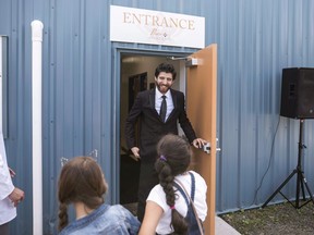 Syrian chocolatier Tareq Hadhad greets children at the door of Peace By Chocolate's newly-opened factory in Antigonish, N.S. on September 9, 2017.