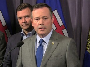 Alberta Opposition United Conservative Leader Jason Kenney speaks to reporters as Edmonton-Riverbend Conservative MP Matt Jeneroux looks on at the party's founding convention at the Sheraton Hotel in Red Deer, Alberta on Friday May 4, 2018.