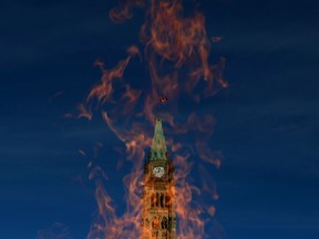 The Peace Tower is pictured through the Centennial Flame on October 23, 2013. MPs will be burning the midnight oil for the next month as the federal government embarks on the perennial scramble to tie up legislative loose ends before Parliament breaks for the summer.THE CANADIAN PRESS/Sean Kilpatrick