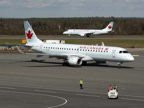 Two Air Canada jets taxi on the tarmac at the Halifax airport on Tuesday, Sept. 20, 2011. Canada's transport minister is rejecting a host of changes senators have made to legislation aimed at unclogging rail shipments and laying the foundation for a new air passenger bill of rights.