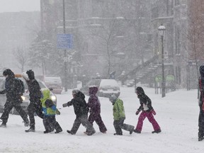 Children from a daycare centre cross a street during a winter storm in Montreal on February 2, 2011. When it comes to affordable daycare, Quebec's low-fee program is the envy of many a parent in other parts of Canada.