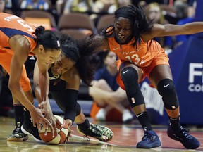 Connecticut Sun guard Jasmine Thomas, left, and forward Chiney Ogwumike, right, battle Las Vegas Aces center Kelsey Bone for a loose ball in the first half of WNBA action Sunday, May 20, 2018, at Mohegan Sun Arena in Uncasville, Conn..