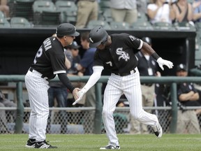 Chicago White Sox's Tim Anderson (7) celebrates his two-run home run off Pittsburgh Pirates starting pitcher Trevor Williams with third base coach Nick Capra during the second inning of a baseball game Wednesday, May 9, 2018, in Chicago. Daniel Palka also scored on the play.