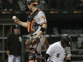 Baltimore Orioles catcher Andrew Susac, left, walks back to the dugout after tagging out Chicago White Sox's Yolmer Sanchez at home during the fifth inning of a baseball game Monday, May 21, 2018, in Chicago.