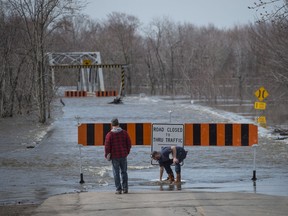 Residents move the barricade out of the rising floodwater from the Saint John River in Lakeville Corner, N.B. on Wednesday, May 2, 2018.