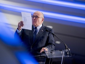 Rudy Giuliani, an attorney for President Donald Trump, pretends spit on a piece of paper as he speaks about the Iran nuclear agreement while speaking at the Iran Freedom Convention for Human Rights and democracy at the Grand Hyatt, Saturday, May 5, 2018, in Washington.