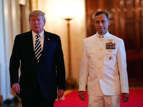 President Donald Trump walks with U.S. Navy Master Chief Special Warfare Operator Britt K. Slabinski to a ceremony where he was to award him with the Medal Of Honor during a ceremony in the East Room of the White House in Washington, Thursday, May 24, 2018.