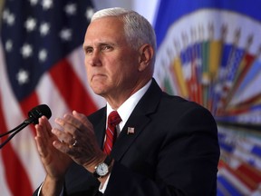 Vice President Mike Pence applauds during a speech at the Organization of American States, Monday, May 7, 2018 in Washington. The Trump administration is imposing sanctions on a former official of the Venezuelan intelligence service, two aides and 20 companies for alleged drug trafficking. Pence announced the sanctions on Pedro Luis Martin Olivares during a speech at the Organization of American States.