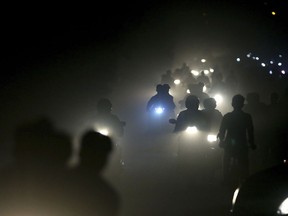 In this Friday, Nov. 10, 2017 file photo, Indian motorists ride past a thick blanket of smog and dust on the outskirts of New Delhi, India. The most recent air pollution data from the World Health Organization gives India a dubious lead. Ten Indian cities lead the list of the 20 most polluted cities in the world.