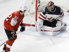 Switzerland's Gaetan Haas, left, scores his side's third goal against Canada's Darcy Kuemper during their semifinal match at the World Hockey Championship on Saturday at the Royal arena in Herning, Denmark.