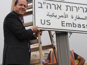 In this photo released by the Jerusalem Municipality, Jerusalem mayor Nir Barkat poses with a new road sign to the new U.S. Embassy in Jerusalem, Monday, May 7, 2018. Jerusalem's city hall says it has put up road signs pointing to the new U.S. Embassy, which is set to move to the contested city next week. Barkat placed the first signs on Monday in the southern Jerusalem neighborhood where the embassy is to be located(Jerusalem Municipality via AP)