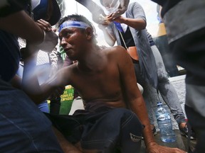 An injured demonstrator receives first aid after being injured by a shotgun blast during clashes with the police, as he was protesting against Nicaragua's President Daniel Ortega, in Managua, Nicaragua, Monday, May 28, 2018. Violence returned to Nicaragua when riot police confronted protesters and students seized a university.