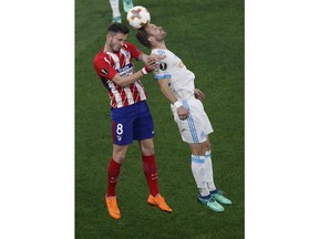 Atletico's Saul Niguez, left, fights to head the ball with Marseille's Valere Germain during the Europa League Final soccer match between Marseille and Atletico Madrid at the Stade de Lyon outside Lyon, France, Wednesday, May 16, 2018.