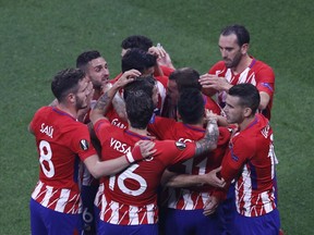 Atletico players celebrate teammate Antoine Griezmann's opening goal during the Europa League Final soccer match between Marseille and Atletico Madrid at the Stade de Lyon outside Lyon, France, Wednesday, May 16, 2018.