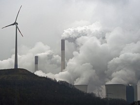 In this file photo dated Monday, Dec. 1, 2014, a wind turbine overlooks the coal-fired power station in Gelsenkirchen, Germany.
