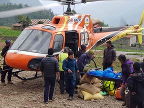 Nepali men carry the body of Japanese climber Nobukazu Kuriki onto a helicopter after it was recovered from Mount Everest, at a helipad in Lukla to be airlifted to Kathmandu on May 21, 2018. A Japanese climber, who lost nine fingers to frostbite on Everest six years ago, died trying to reach the mountain's summit May 21, 2018, officials said, the third climber to perish on the world's highest peak this month.