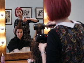 In this Wednesday, May 16, 2018 photo, Lisa Meyer blow drys the hair of a client at her Hair and Beauty shop in London. Meyer's hair salon is a cozy place where her mother serves homemade macaroons, children climb on chairs and customers chat above the whirr of hairdryers. Most of the time Meyer is focused on hairstyles, color trends and keeping up with appointments. But now she's worried about how the European Union's new data protection law will affect her business as she contacts customers to seek permission to store their details on her computer.