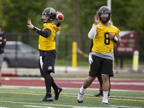 Quarterback Johnny Manziel, left, goes through drills with Hamilton Tiger-Cats teammate Jeremiah Masoli on the field at McMaster University on Sunday, May 20, 2018.