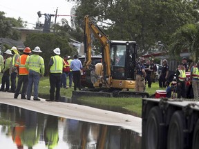 A crane boom crashed into several homes, causing injuries in Lauderhill, Fla., on Wednesday afternoon, May 30, 2018, a fire official said. Authorities say at least two people were injured when the crane collapsed.  Lauderhill Fire Rescue spokeswoman Jerry Gonzalez says the crane was being used to put up Florida Power and Light electric poles when it fell onto two houses.