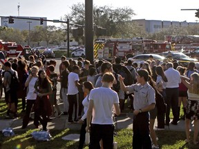 FILE - In this Wednesday, Feb. 14, 2018, file photo, students are released from a lockdown following a shooting at Marjory Stoneman Douglas High School in Parkland, Fla. If you want to know where mass school shootings are most likely to occur, look no farther than small-town and suburban America.