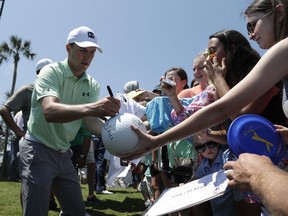 Jordan Spieth signs autographs during the practice round at the Players Championship golf tournament, Wednesday, May 9, 2018, in Ponte Vedra Beach, Fla.