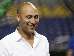 Miami Marlins CEO Derek Jeter smiles as he watches batting practice before a baseball game against the Los Angeles Dodgers, Wednesday, May 16, 2018, in Miami.