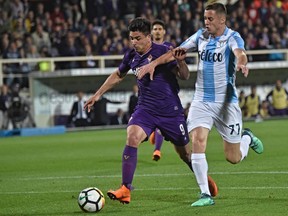 FILE - In this Wednesday, April 18, 2018. file photo, Fiorentina's Giovanni Simeone, left, and Lazio's Adam Marusic go for the ball during the Serie A soccer match between Fiorentina and Lazio at the Artemio Franchi stadium in Florence, Italy. Nearly 20 years after his father scuppered Juventus' title hopes, Giovanni Simeone has made it up to the Serie A club. Current Atletico Madrid coach Diego Simeone fired Lazio to a 1-0 win against Juventus in April 2000, with the capital club going on to finish a point above the Bianconeri to win the title. On Sunday, 18 years later, the younger Simeone netted a hat trick to help Fiorentina beat Juve's closest challengers Napoli 3-0 and leave the Bianconeri on the brink of a seventh successive title.