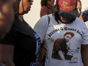 FILE - In this Oct. 20, 2015, file photo, friends and family of Corey Jones, seen on the t-shirt, attend a news conference led by Bishop Sylvester Banks, Sr., grandfather of Jones, outside Bible Church of God in Boynton Beach, Fla. Prosecutors and attorneys for fired Palm Beach Gardens officer Nouman Raja clashed Monday, May 7, 2018, during a hearing over whether his fatal shooting of 31-year-old Jones was justified.