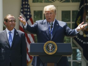 FILE - In this May 11, 2018 file photo President Donald Trump speaks during an event about prescription drug prices with Health and Human Services Secretary Alex Azar in the Rose Garden of the White House in Washington.